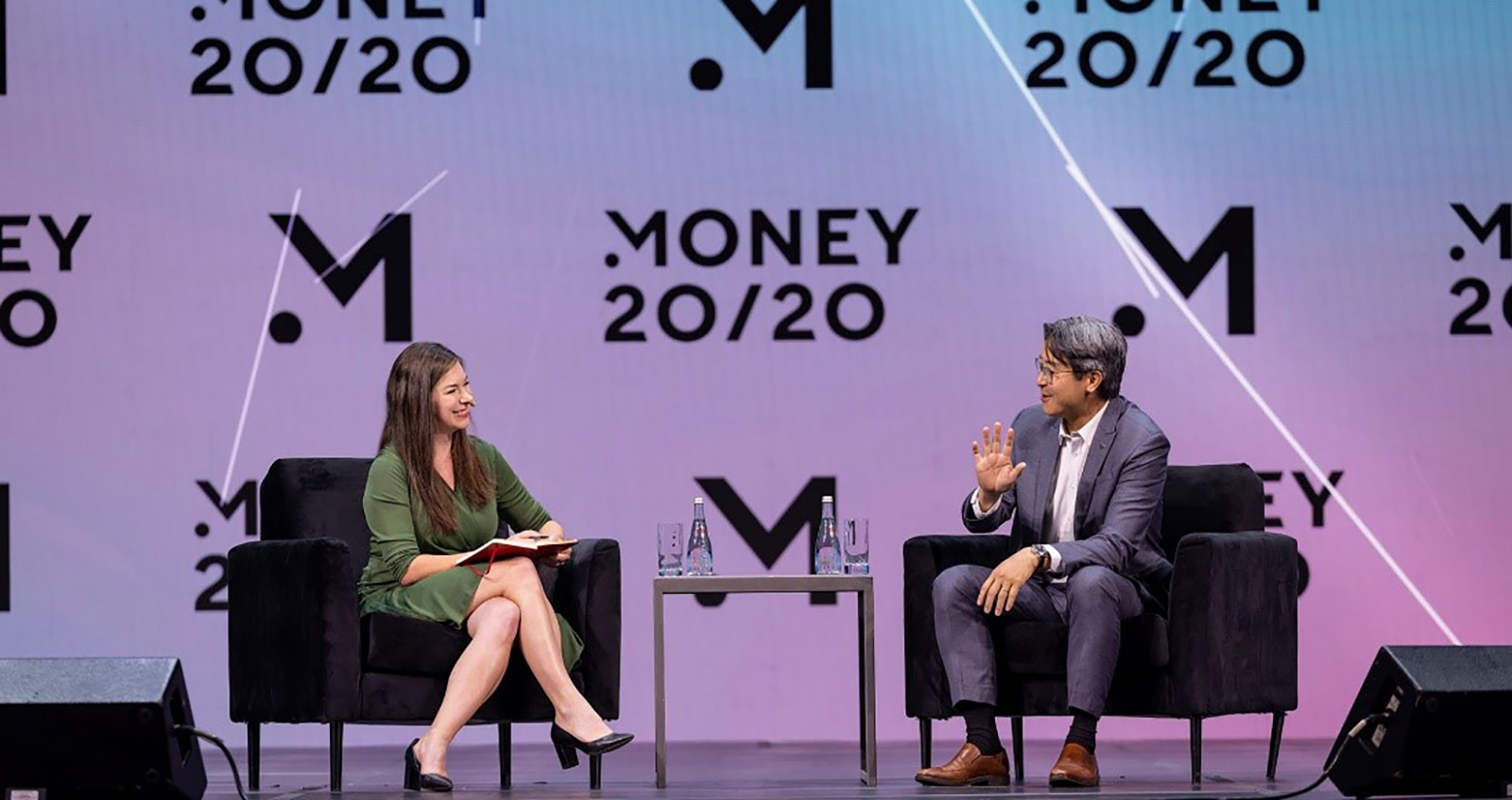 Acting Comptroller Hsu participates in a discussion at Money 20/20, seated onstage in a black chair opposite a moderator, against a backdrop featuring the event's logo.