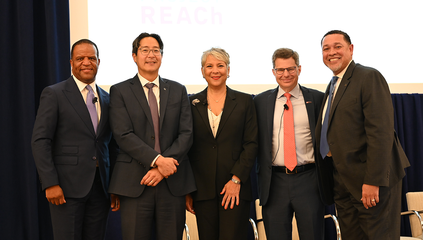 Acting Comptroller Hsu stands with Project REACh founders and Director of Minority Outreach Andrew Moss, posing for a group photo in front of a 'Project REACh' backdrop.